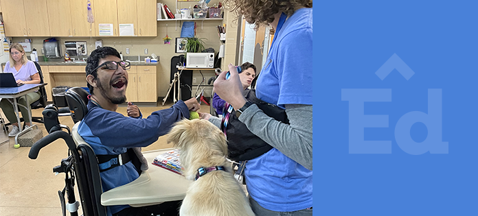 Smiling student throwing a tennis ball to a service dog