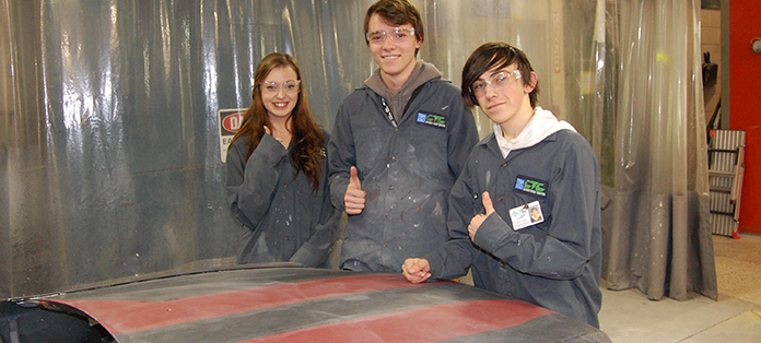 guys and gals in the auto body lab showing thumbs up.
