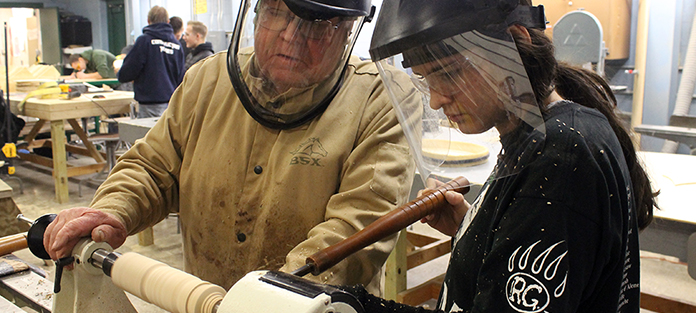 Instructor and student working on a wood lathe